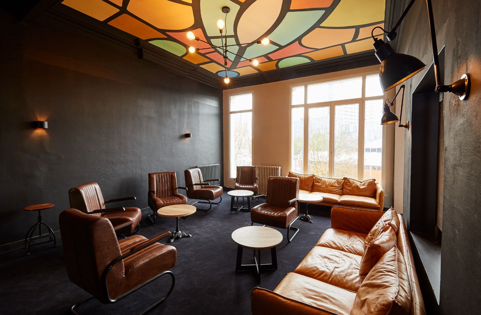 Salon à l'étage avec fauteuils en cuir et plafond peint coloré
